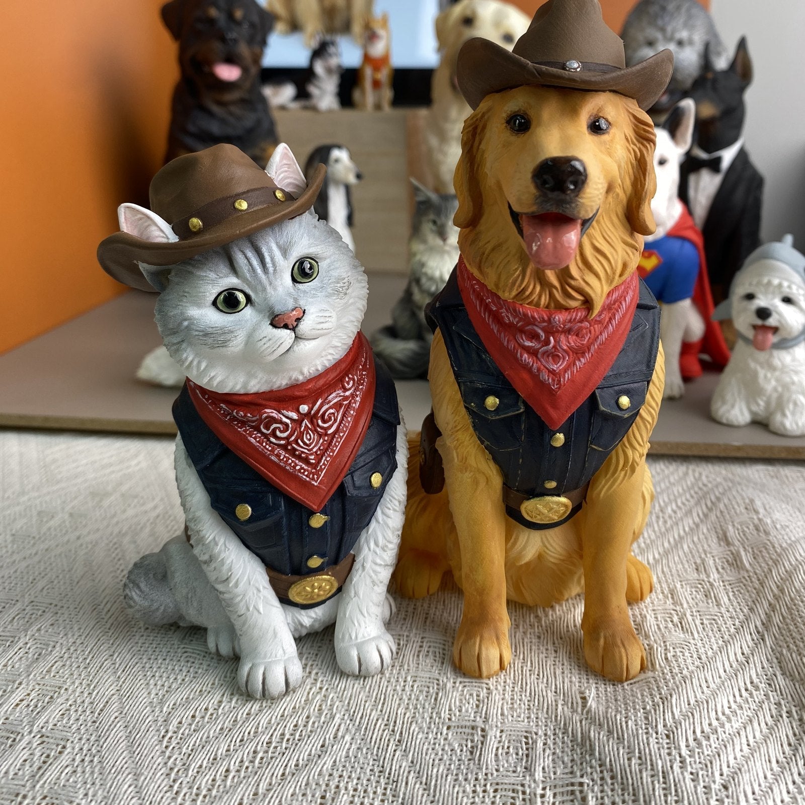 Custom cat and golden retriever figurines in matching cowboy hats, denim vests and red bandanas