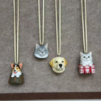 Custom pet charms of a corgi, tabby cat, labrador and silver cat hanging on cords
