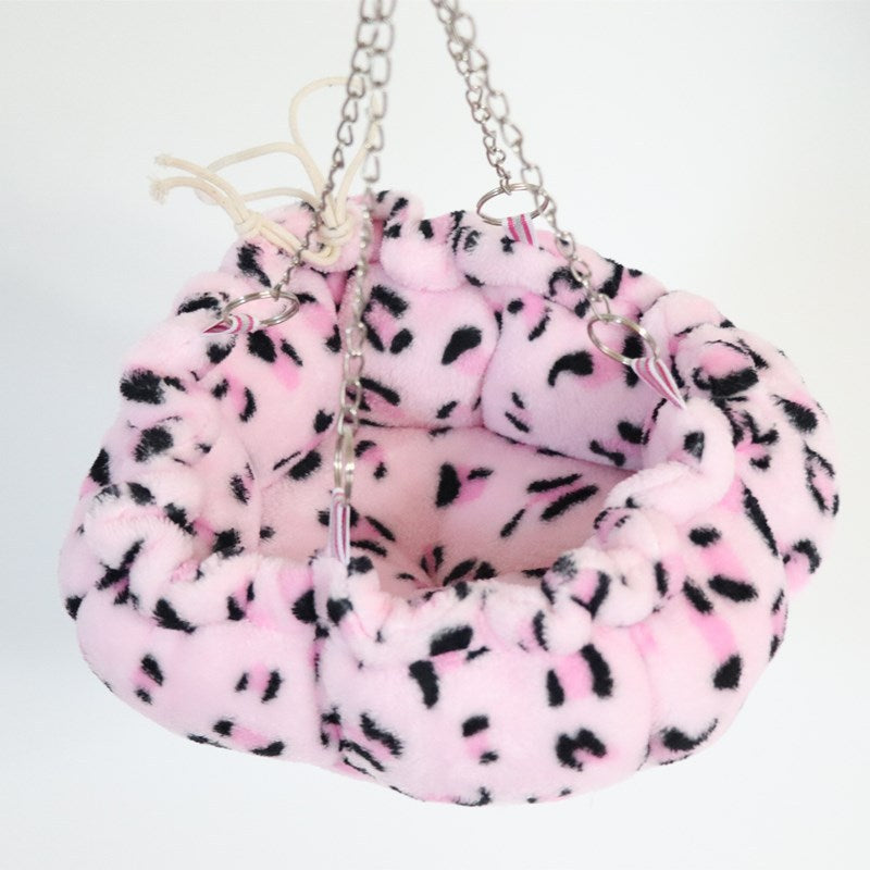 A hamster hanging hammock bed is a type of pet accessory that is designed to provide a comfortable and cozy resting spot for small pets such as hamsters. It is typically made of soft, lightweight material, and can be hung from the cage bars using a drawstring or other attachment method. The hammock bed allows the hamster to relax and nap off the cage floor, providing them a sense of security and comfort. Some hammock beds have a drawstring closure Main image
